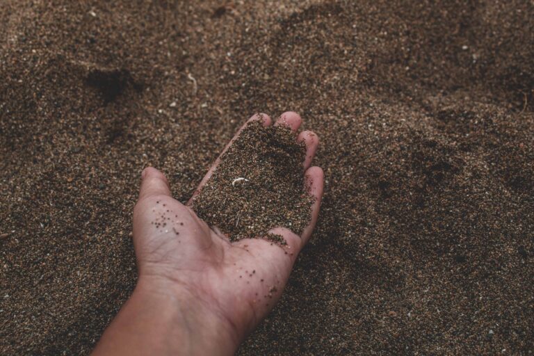 contact header: hand picking up soil